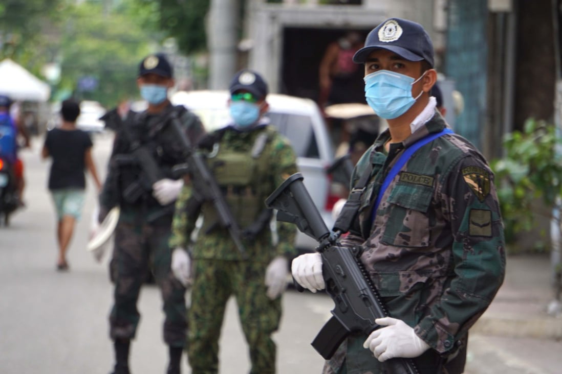 Armed policemen man a checkpoint along a road in Cebu City on June 24 after the government tightened its enhanced community quarantine restrictions amid a spike in Covid-19 cases. Photo: AFP