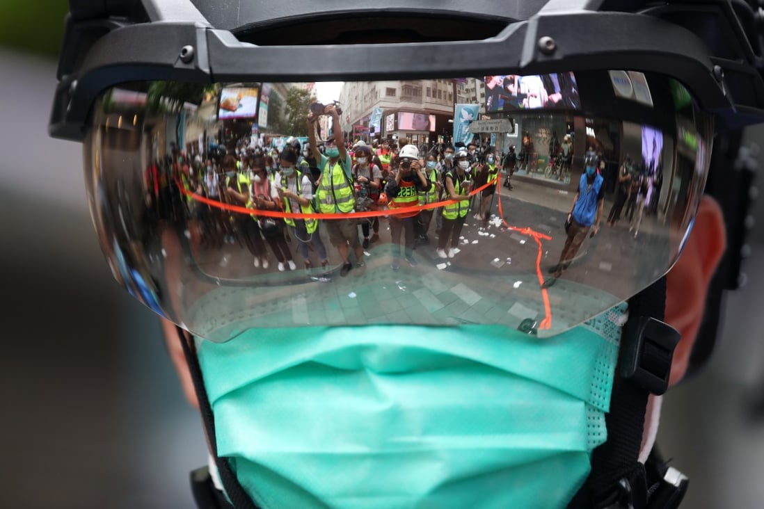 Journalists are reflected in a riot officer’s visor while covering a protest against Hong Kong’s national security law on July 1. Concerns are growing among local media figures that elements of the new law could constrain traditional press freedoms in the city. Photo: Xiaomei Chen