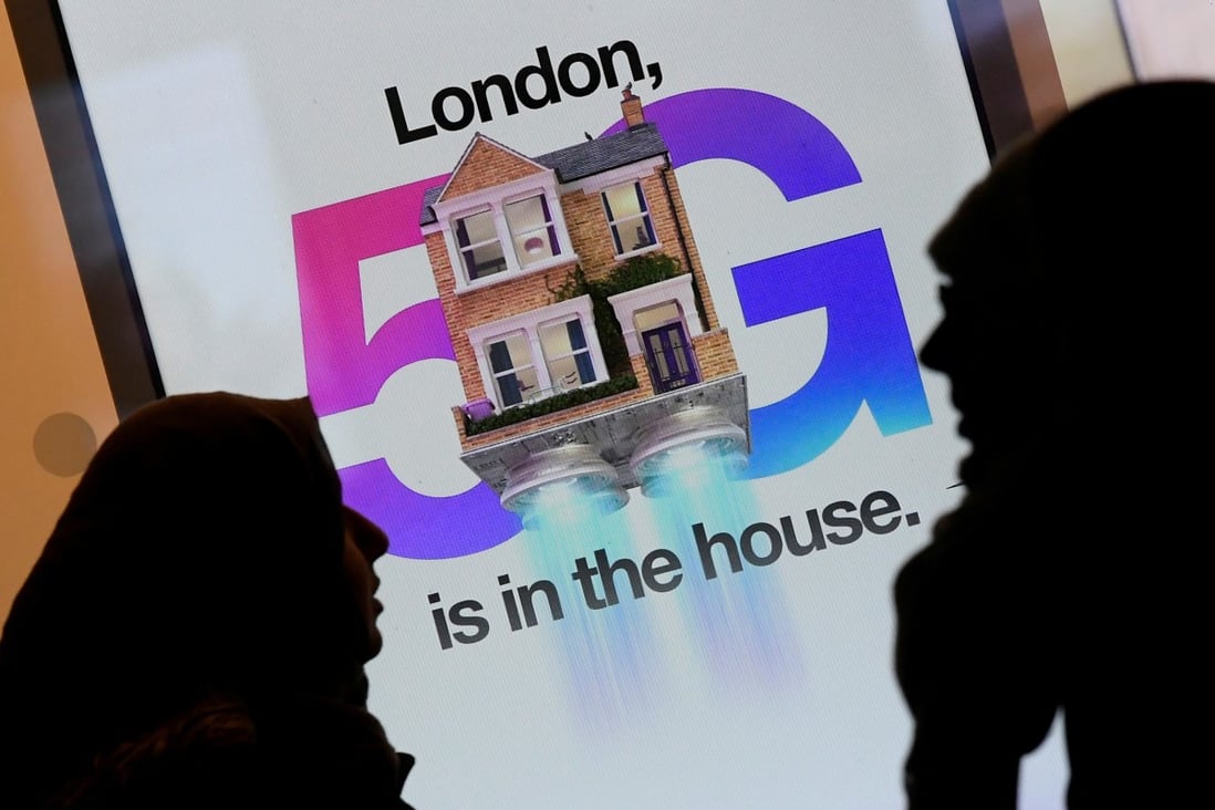 Pedestrians walk past an advertisement promoting the 5G data network at a mobile phone store in London. Photo: Reuters
