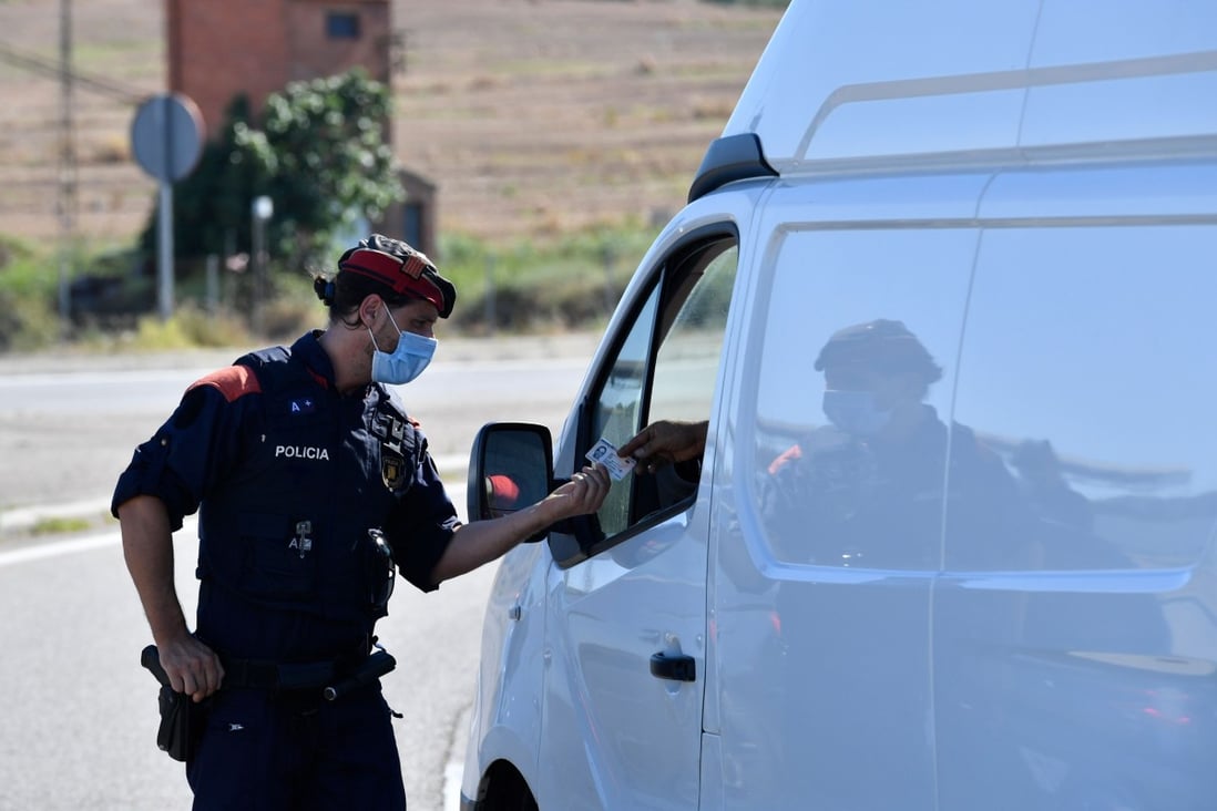 A member of the Catalan regional police force Mossos d'Esquadra controls a checkpoint on the road leading to Lleida. Photo: AFP