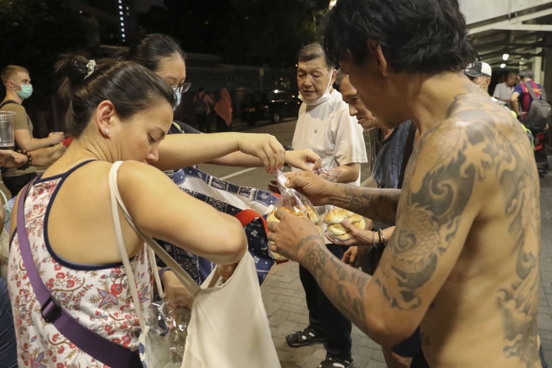 Members of charity group ImpactHK hand out food and other necessities to homeless people in Yau Ma Tei, Hong Kong, during one of their regular “kindness walks”. Photo: Dickson Lee