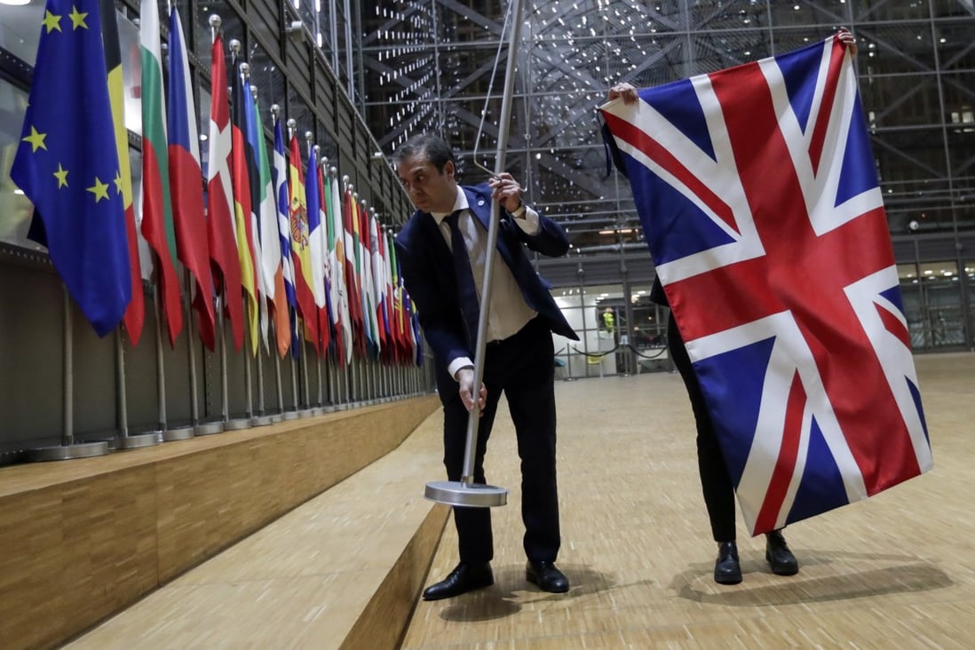 Staff remove the British flag from the European Council in Brussels on January 31 when Britain officially exited the EU, beginning an 11-month transition period. Photo: EPA-EFE