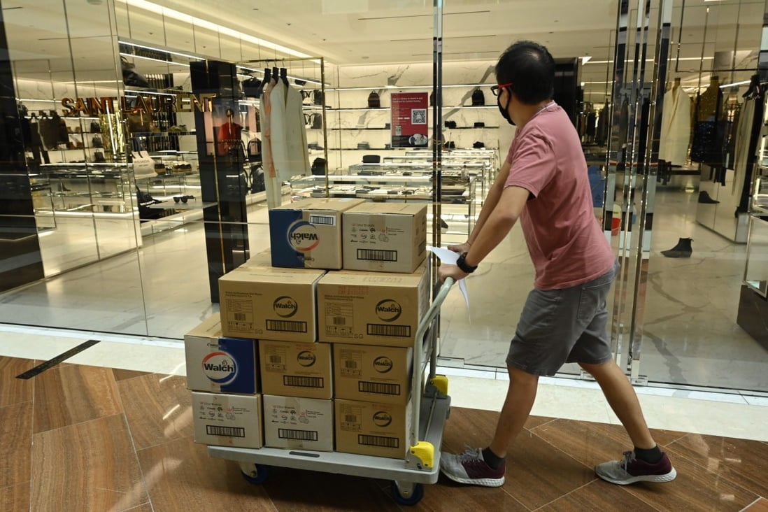 A worker pushes a trolley with goods past a luxury outlet at Marina Bay Sands shopping centre in Singapore. Photo: AFP