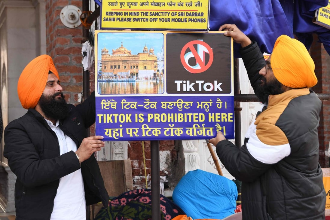 In this file photo taken on February 10, 2020 Sikh volunteers hang a sign reading 'Tiktok is prohibited here', at the Golden Temple in Amritsar. Photo: AFP
