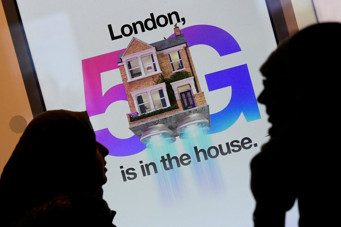 Pedestrians walk past an advertisement promoting 5G mobile service at a store in London on January 28. Photo: Reuters