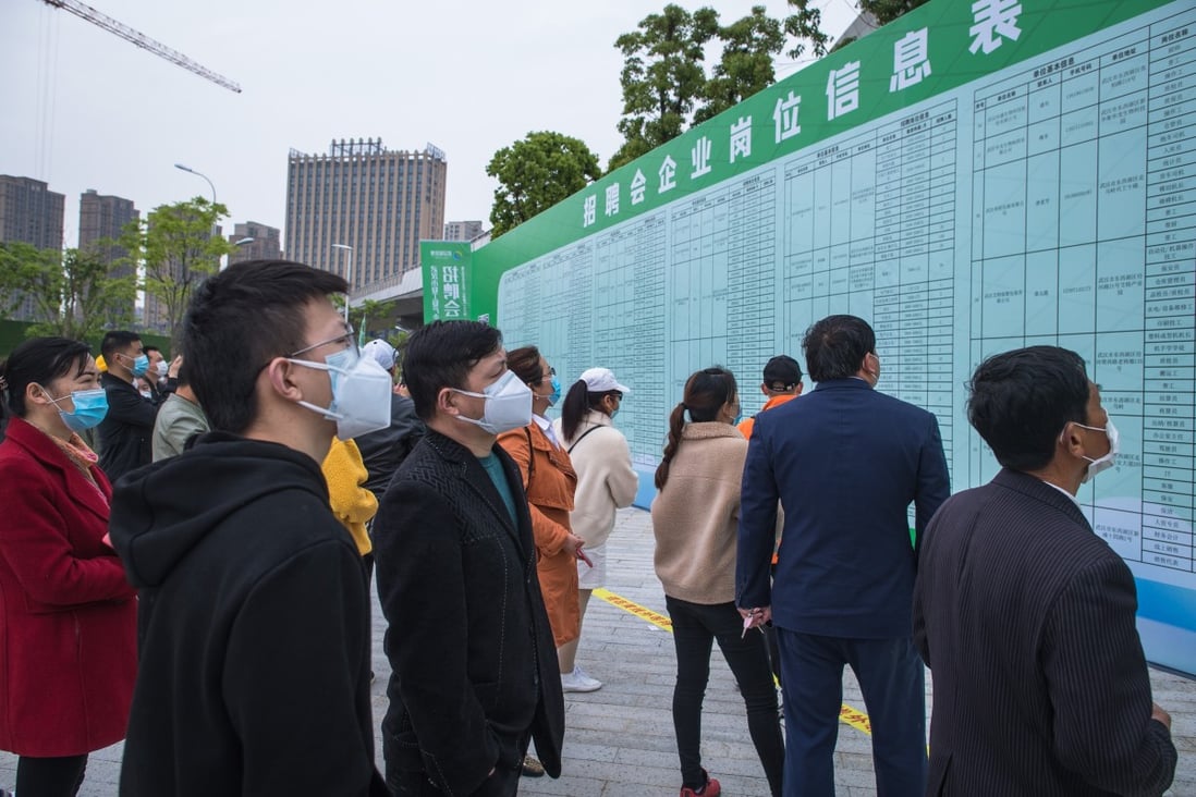 Job applicants read recruitment information at an on-site job fair in Wuhan, capital of central China's Hubei province, on April 21. Photo: Xinhua