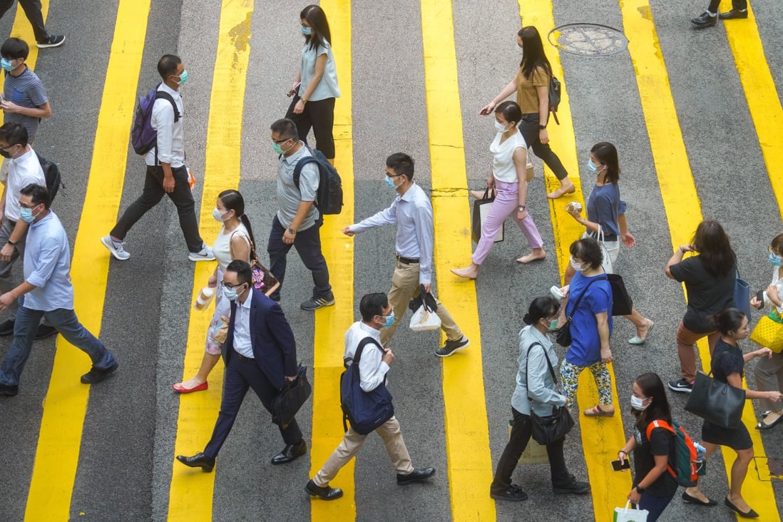 Pedestrians in face masks are seen crossing the road in Central Business District. Unofficial estimates put the number of Chinese workers and residents in Hong Kong at 80,000 to 150,000. Photo: Winson Wong