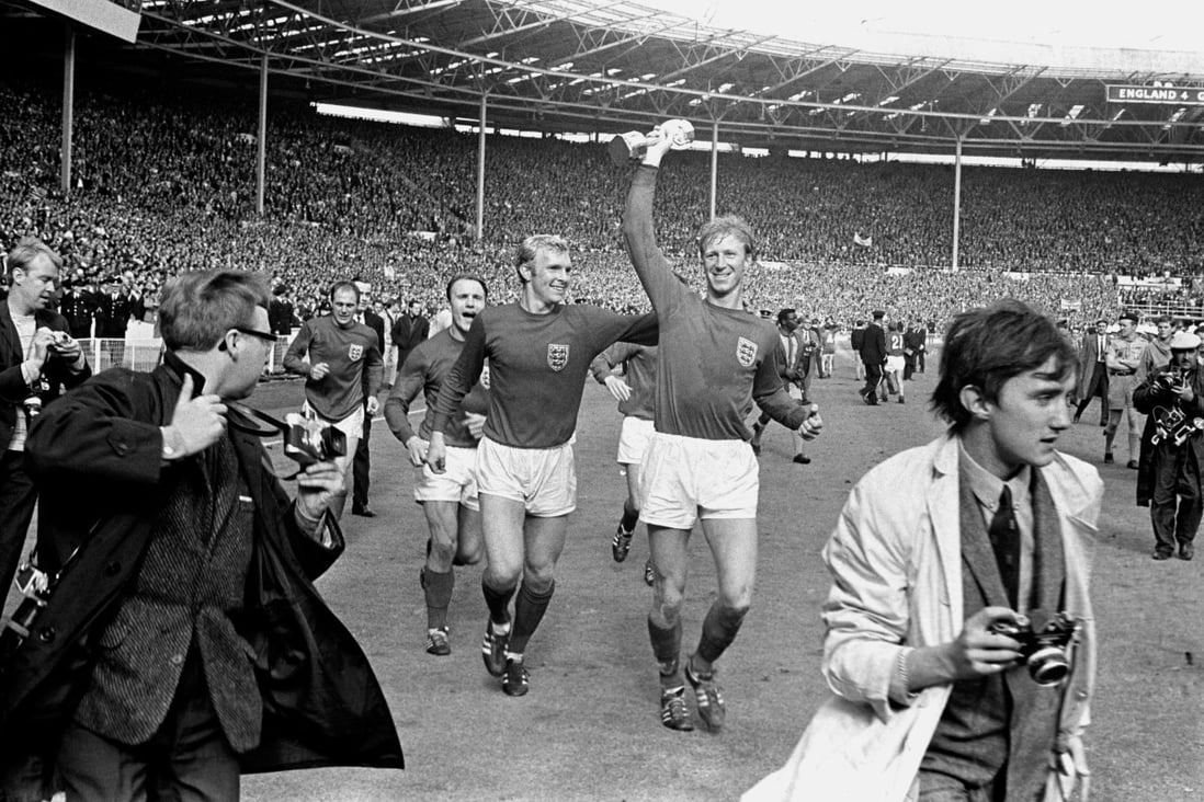 Jack Charlton holds the Jules Rimet trophy aloft as he parades it around Wembley with Bobby Moore after their 4-2 win over West Germany. Photo: AP