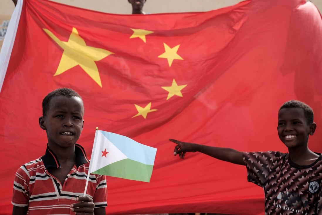 A Djiboutian boy holds his national flag in front of China’s at the launch of a housing construction project backed by China Merchant Group. Photo: AFP
