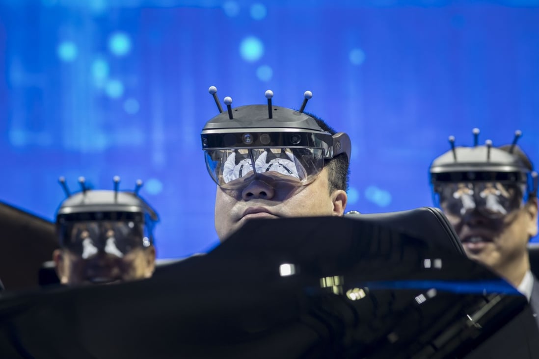 Visitors wearing virtual reality (VR) headsets try a driving system at a Nissan Motors booth during CES Asia in Shanghai on June 11, 2019. Photo: Bloomberg