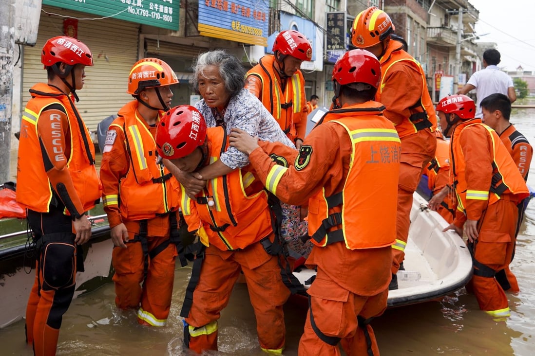 Firefighters bring a villager to safety during their rescue mission on Saturday. Photo: Tom Wang