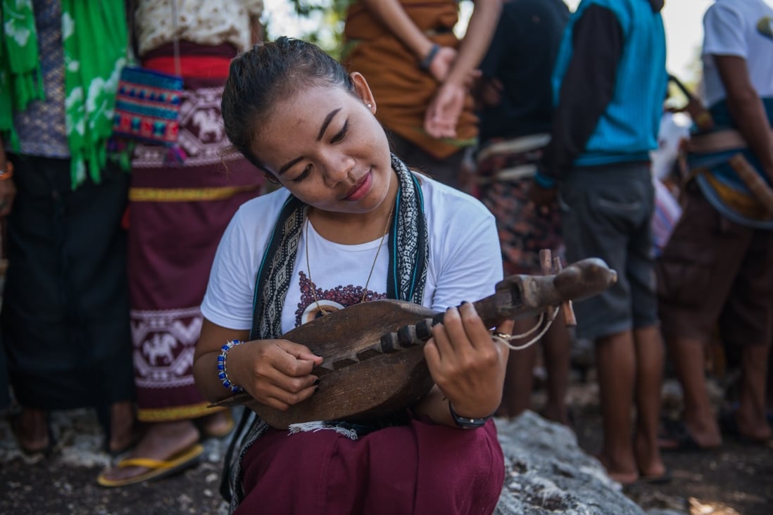 A young woman in Sumba plays a musical instrument, the junga. The Indonesian island is known for its charm and traditional culture, but one tradition, known as catch-a-bride, involving the abduction of young women for forced marriage, has led to a backlash recently. Photo: Shutterstock