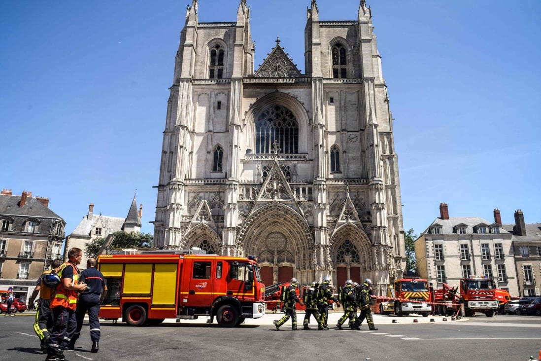 Firefighters are seen at the Cathedral of St Peter and St Paul in Nantes after a fire ravaged parts of the Gothic building on July 18. A man has been questioned after police opened an arson probe. Photo: AFP