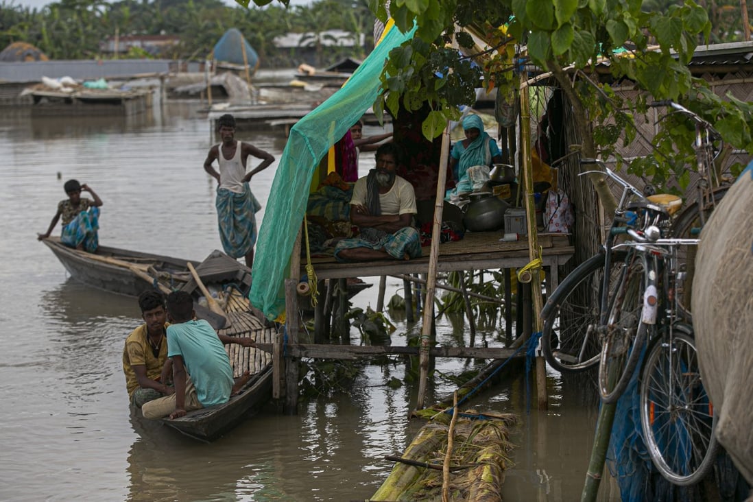 People affected by flooding take shelter at a temporary structure near their submerged house along river Brahmaputra in Morigaon district, Assam, after floods triggered by heavy monsoon rains in the region. Photo: AP