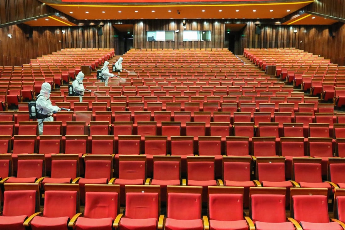 Staff members spray disinfectant at a theatre on May 12 as it prepares to reopen in Yantai, a city in China's eastern Shandong province. Photo: AFP