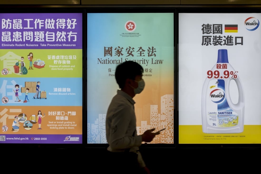 A pedestrian walks past a government-sponsored advertisement promoting the national security law in Hong Kong. Photo: Bloomberg