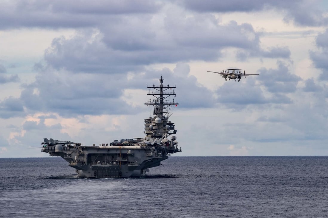 An E-2D Advanced Hawkeye flies past the aircraft carrier USS Ronald Reagan during a drill in the South China Sea on July 6. Photo: EPA-EFE