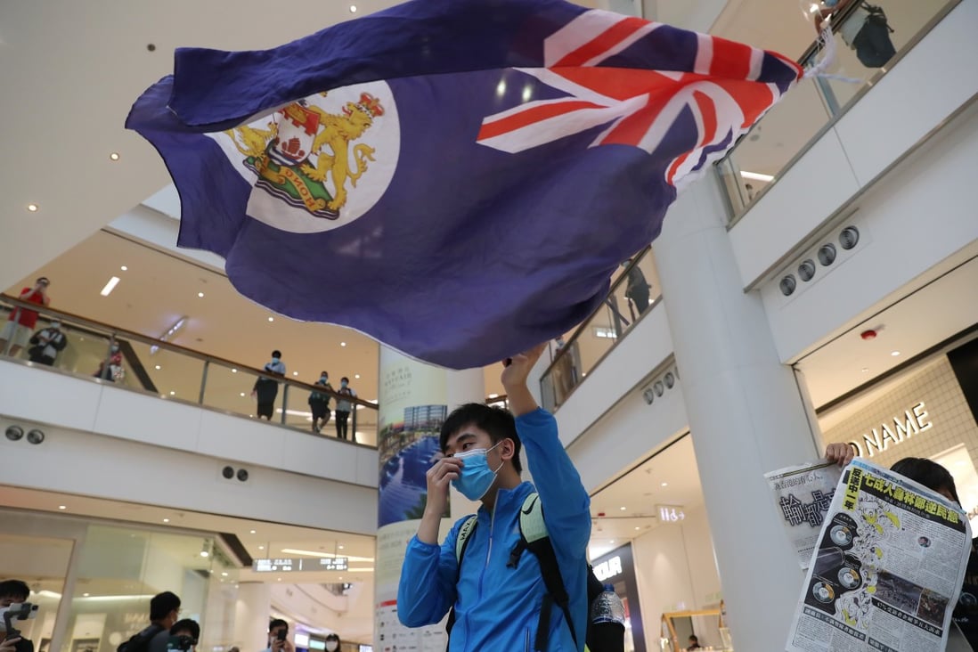 An anti-government protester waves the flag of colonial-era Hong Kong during a protest in a shopping mall on June 8. Photo: Sam Tsang