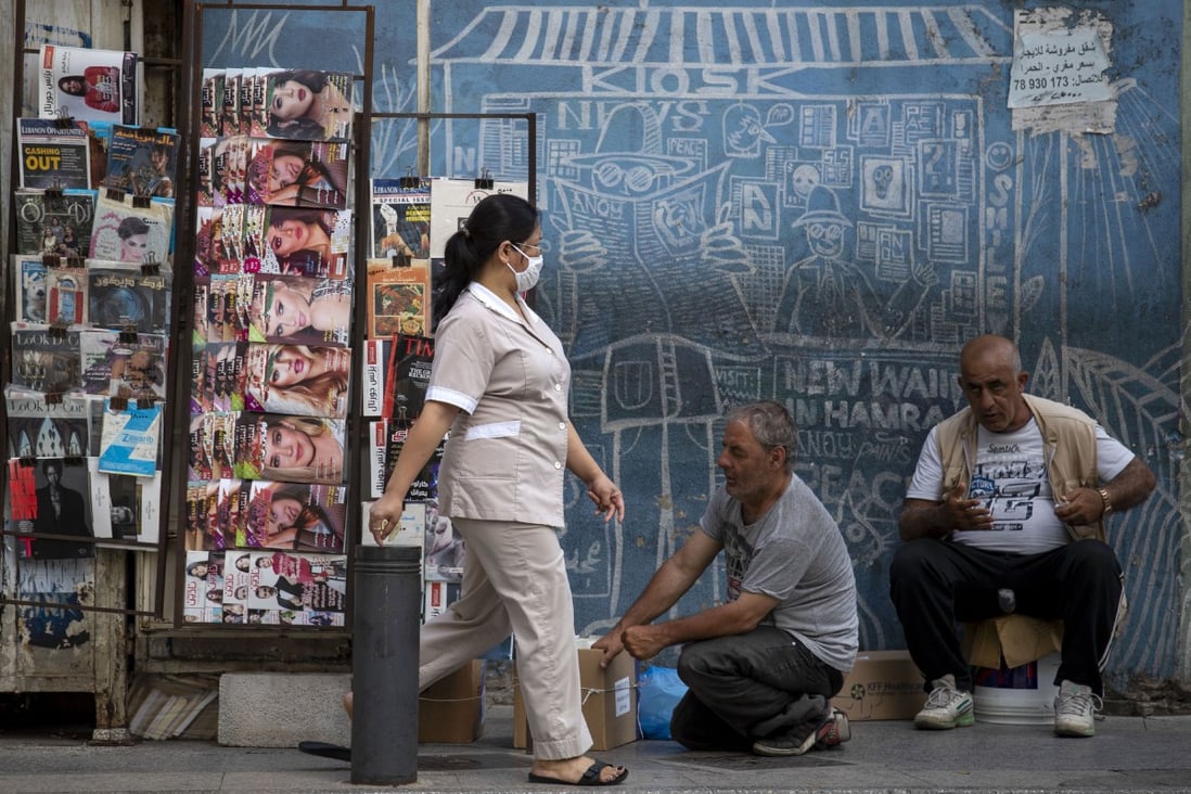 A maid from the Philippines passes a newspaper kiosk in Beirut, Lebanon. Lebanon spends about 41 per cent of its revenue on debt service. Photo: AP