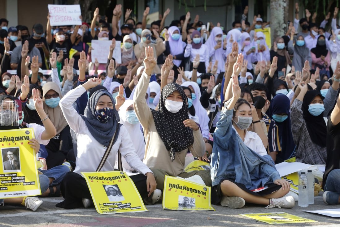 Thai protesters make the three-fingered Hunger Games salute. Photo: AFP