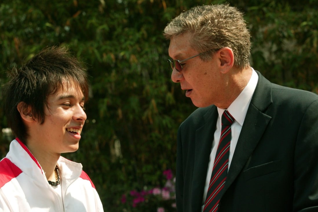 Diocesan Boys' School (DBS) old boy William Hill, Hong Kong's 400m record holder, talks to La Salle College student Sandro Bassetto at Wan Chai Sports Ground. Sandro came within a second of beating the record (49.1 seconds) at the 2004 interschool athletics finals. Photo: SCMP