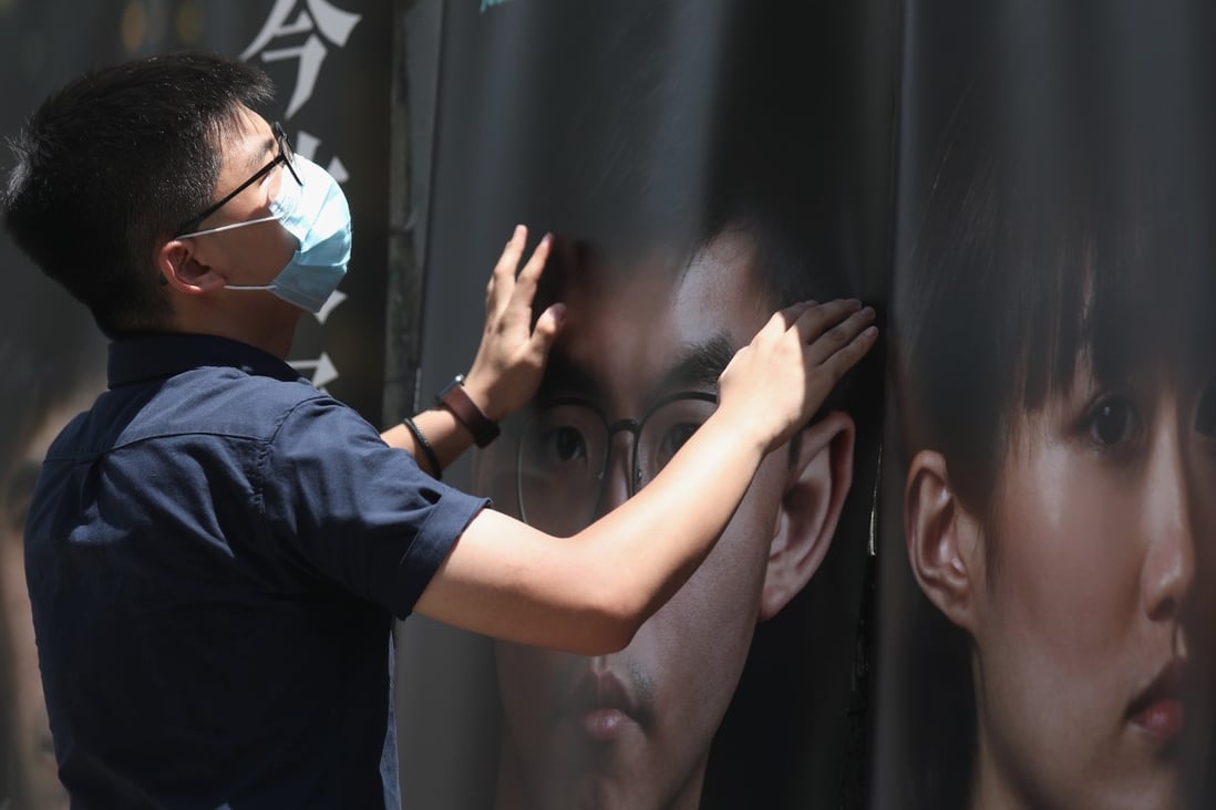 Joshua Wong sets up campaign posters during the opposition camp’s recent primary election. Photo: Xiaomei Chen