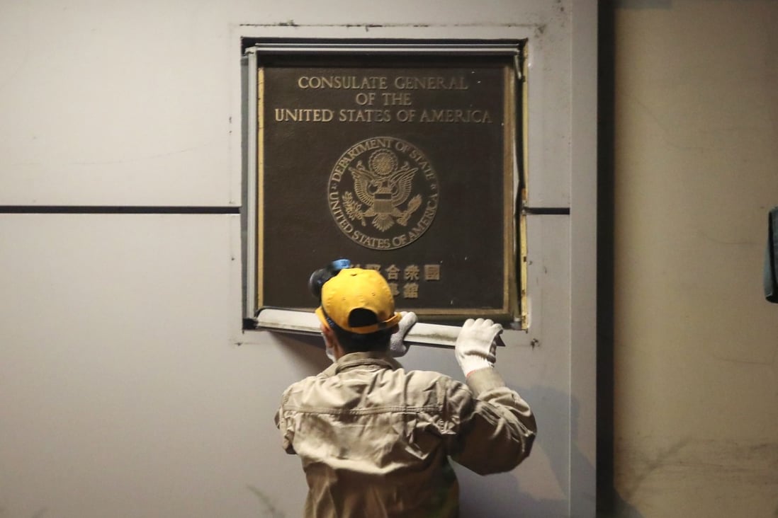 Workers remove a plaque marking the US consulate in Chengdu on Sunday night after the office was closed as part of a diplomatic row. Photo: Simon Song