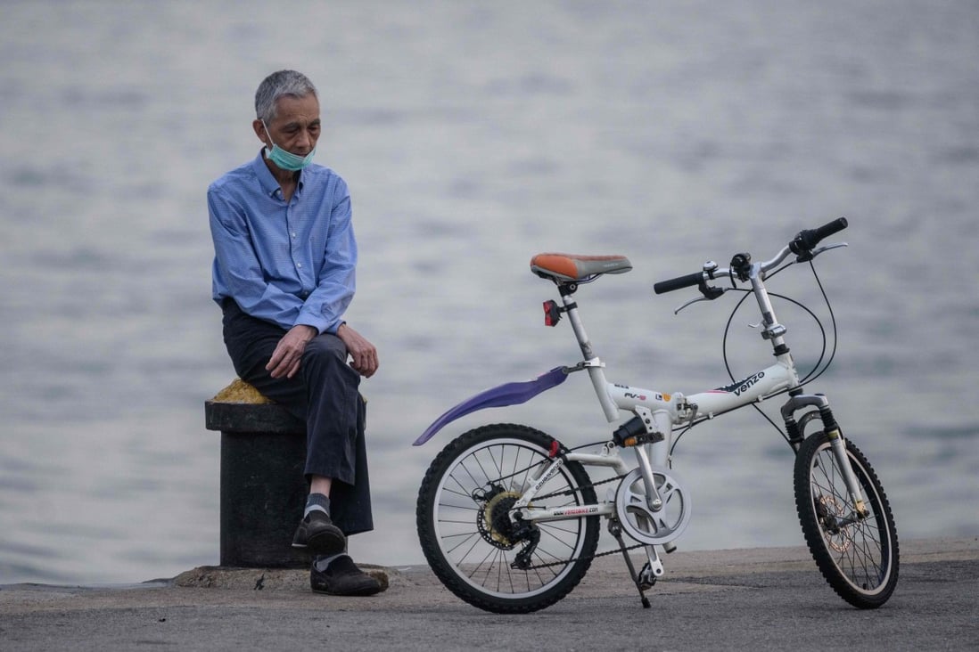 An elderly man rests next to his bicycle on a cargo dock in Hong Kong on April 21. Older adults living alone continue to struggle as Hong Kong grapples with a third Covid-19 wave. Photo: AFP