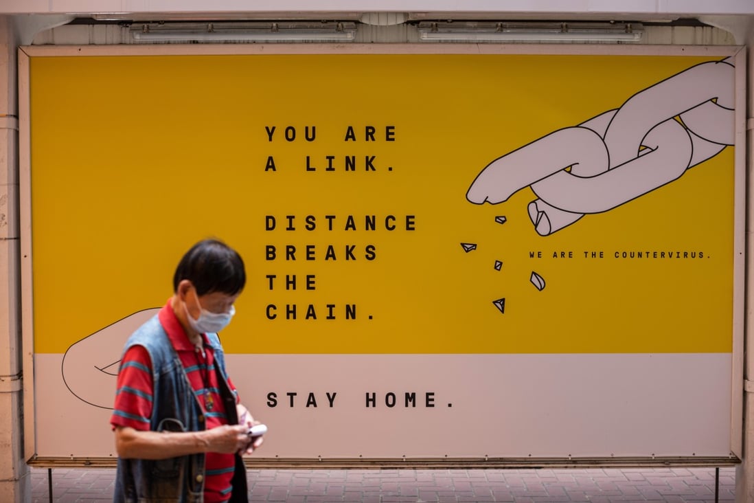 A man wearing a face mask walks past a billboard promoting practices to minimise the spread of Covid-19, in Causeway Bay on May 5. Photo: EPA-EFE