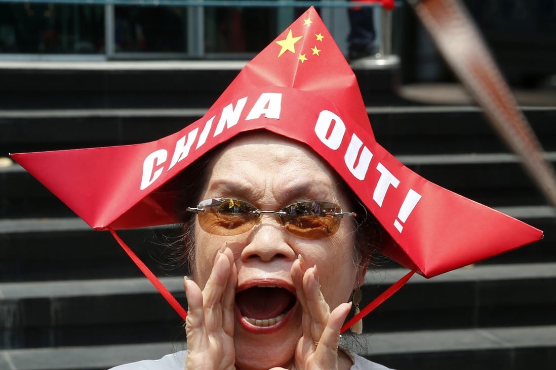 A protester wearing a boat-shaped hat shouts slogans against China’s incursions in the South China Sea. While Philippine diplomats work to strengthen relations with Beijing, there is strong anti-China sentiment among Filipinos. Photo: AP