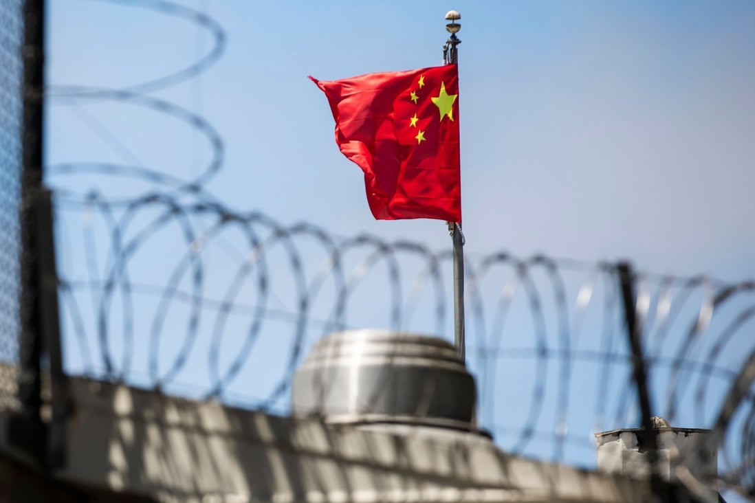 The Chinese flag behind barbed wire at Beijing’s San Francisco consulate. Photo: AFP
