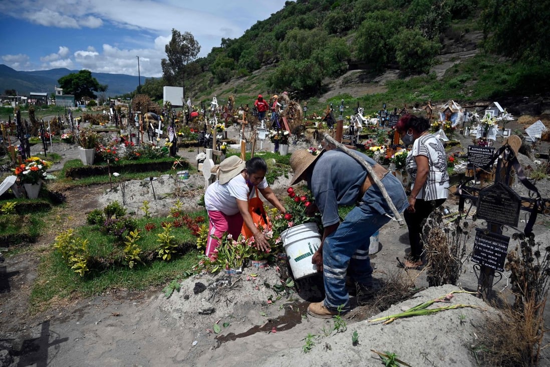 Relatives of Covid-19 victims attend to their graves in a cemetery on the outskirts of Mexico City. Photo: AFP