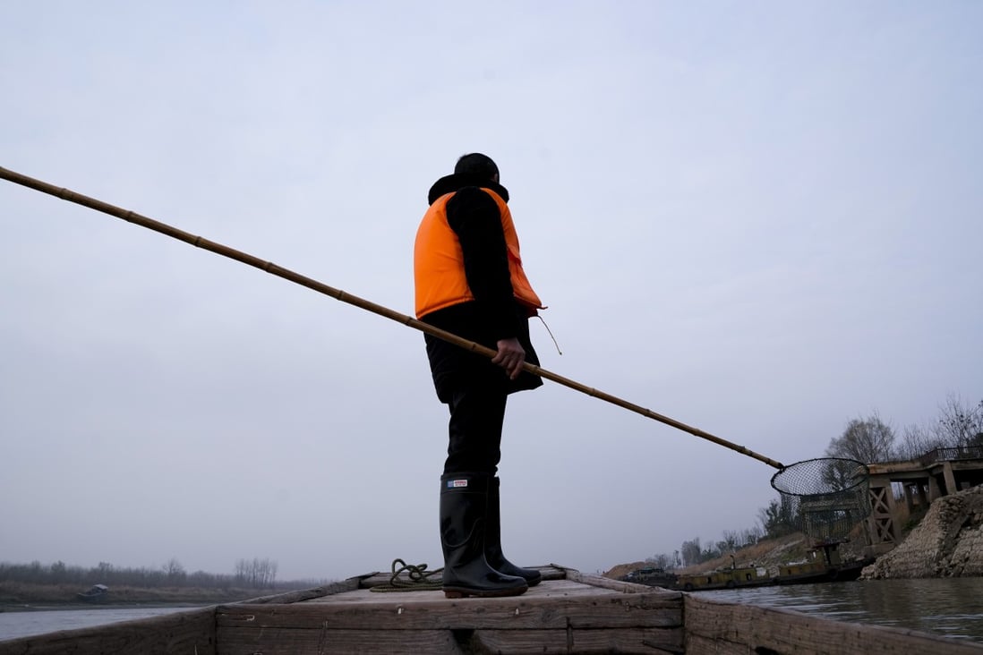 After giving up his licence, this fisherman clears rubbish from the Yangtze in Anhui province. Photo: Xinhua