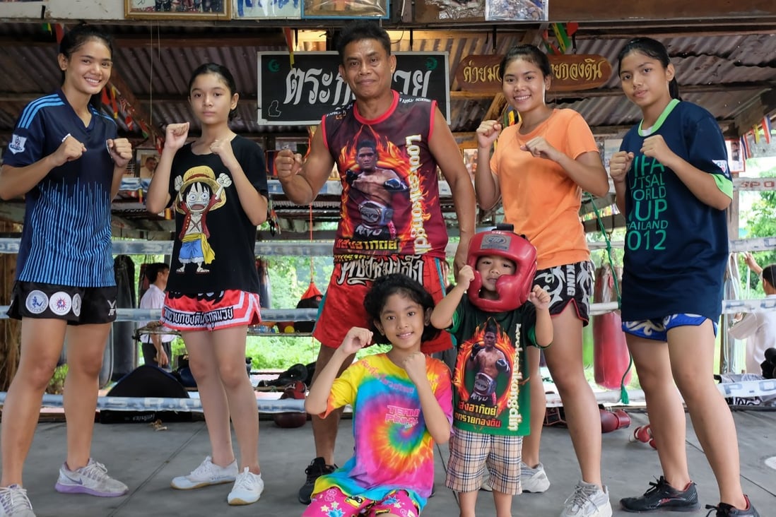Family patriarch Nopparit Yoohanngoh, who has trained all of his 16 children in Muay Thai, poses with five of his daughters and a grandchild at his small gym in Bangkok. Photo: Tibor Krausz
