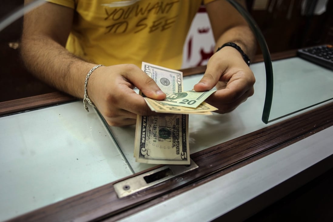A worker at a currency exchange bureau handles US dollar banknotes in Beirut, Lebanon, on July 21. The dollar is universally accepted for transactions, portfolio investment and speculation. It is without parallel as a multipurpose all-rounder. Photo: Bloomberg