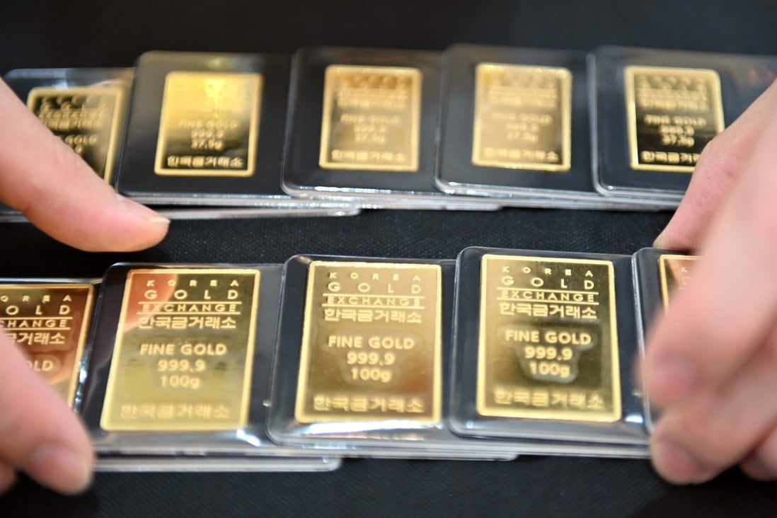 An employee displays gold bars at a Korea Gold Exchange shop in Seoul on July 30. Virus uncertainty and China-US tensions have sent gold prices soaring nearly 30 per cent this year. Photo: AFP