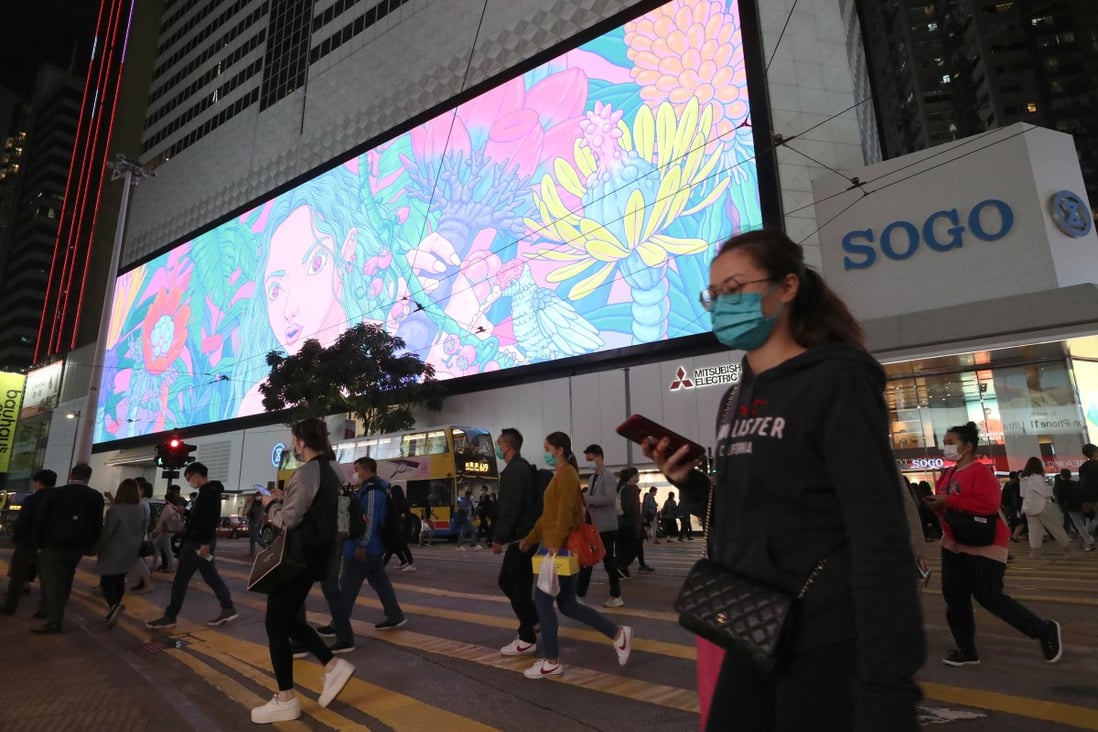 Shoppers in protective masks cross the road in front of the Sogo department store in Causeway Bay. Photo: Edmond So