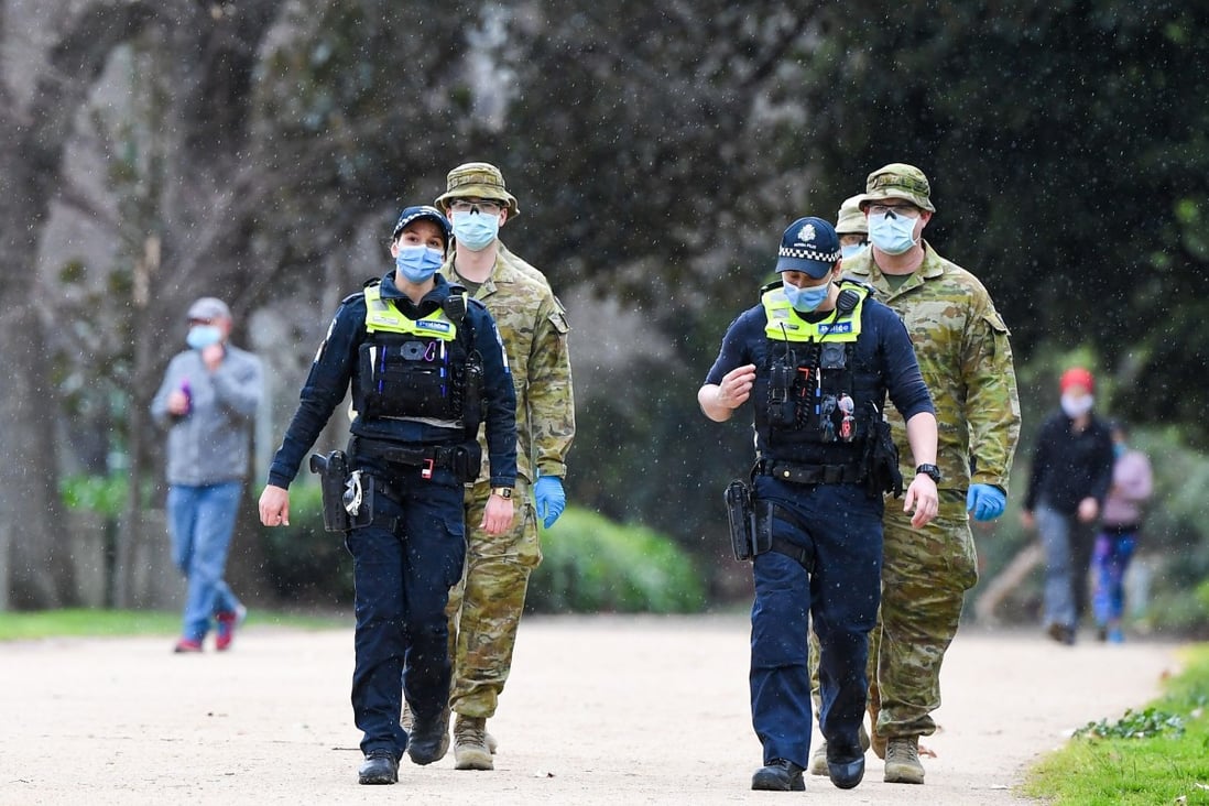 Police officers and soldiers patrol a popular running track in Melbourne on Tuesday. Photo: Agence France-Presse