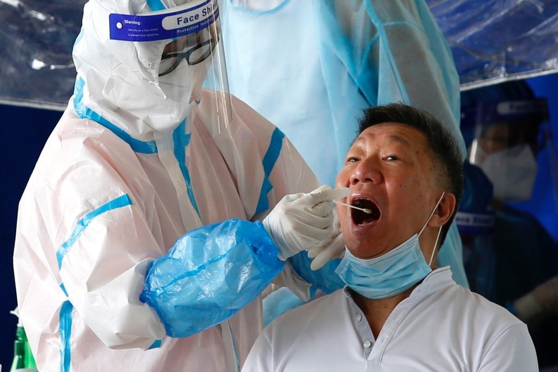 A swab sample is collected from a taxi driver by a Covid-19 health worker in Hong Kong last month. Photo: Reuters