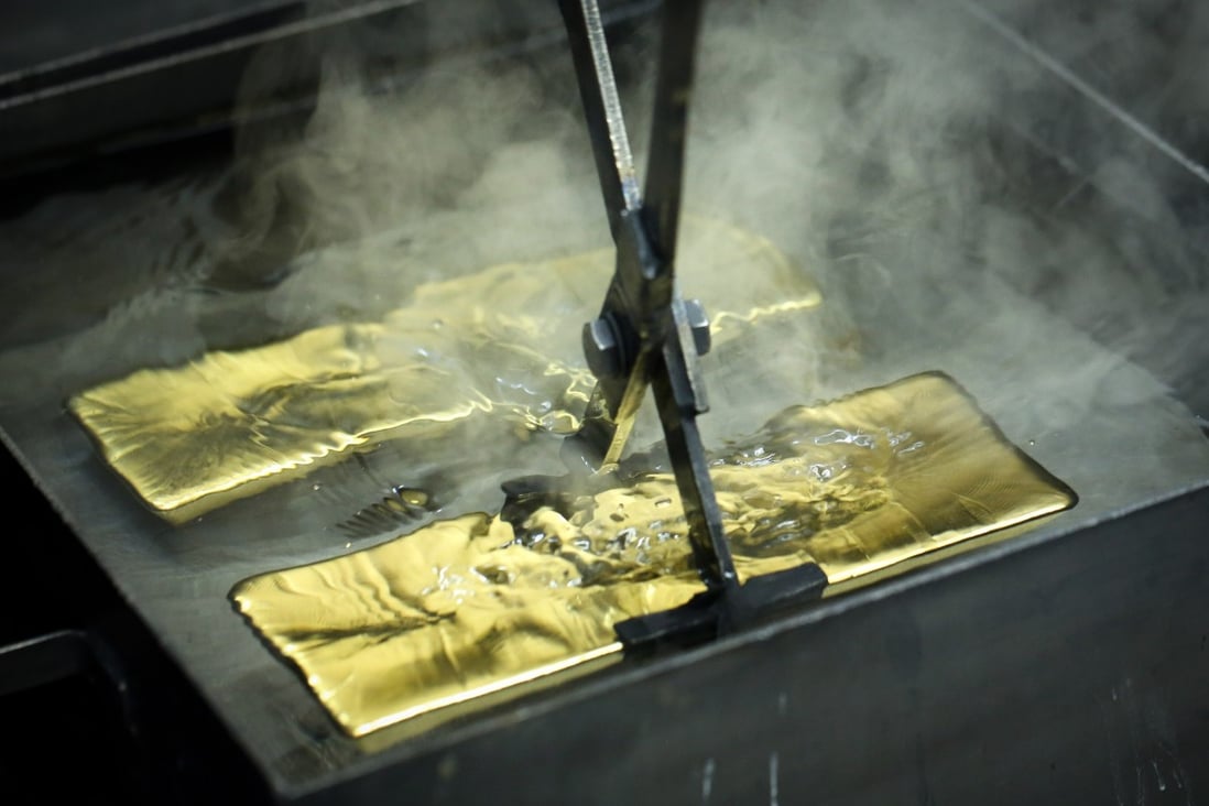 A worker plunges a gold ingot into a cooling bath at the Uralelectromed Copper Refinery in Verkhnyaya Pyshma, Russia, on Thursday. Gold surged to a fresh record on Friday, fuelled by a weaker dollar and low interest rates. Photo: Bloomberg