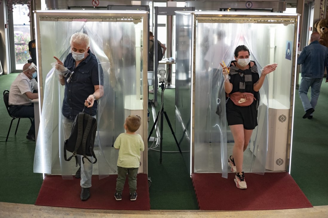 People pass through booths equipped with disinfectant sprays at a shopping centre in Moscow, Russia. Photo: AP
