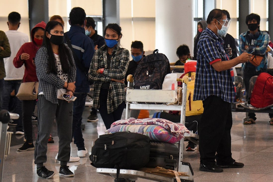 Stranded passengers wait for updates at the airport in Manila on Tuesday after all domestic flights were cancelled following new coronavirus restrictions. Photo: AFP