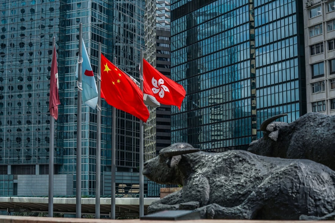 The flag of the Hong Kong Special Administrative Region, right, flies alongside the flag of China outside the Exchange Square complex. Photo: Bloomberg