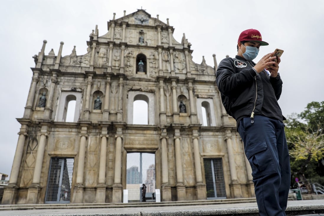 A man checks his phone in front of the Ruins of Saint Paul’s in Macau. The city recorded fewer than 50 confirmed cases of Covid-19 and no fatalities as of August 7. Photo: Winson Wong