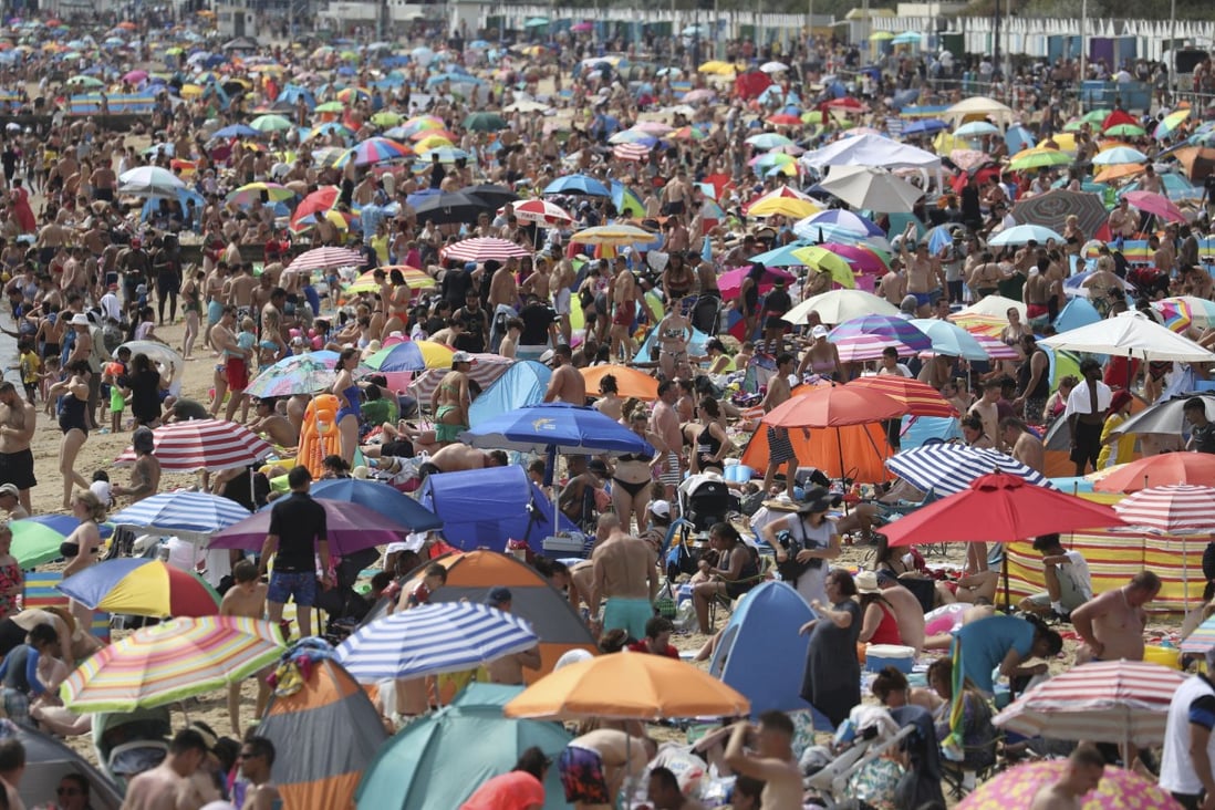 People enjoy the hot weather on Bournemouth beach in England on Saturday. Photo: PA via AP