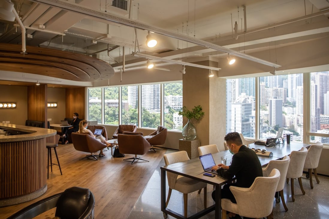 People wearing masks sit with their laptops at The Executive Centre’s co-working space in Hong Kong. Photo: Bloomberg