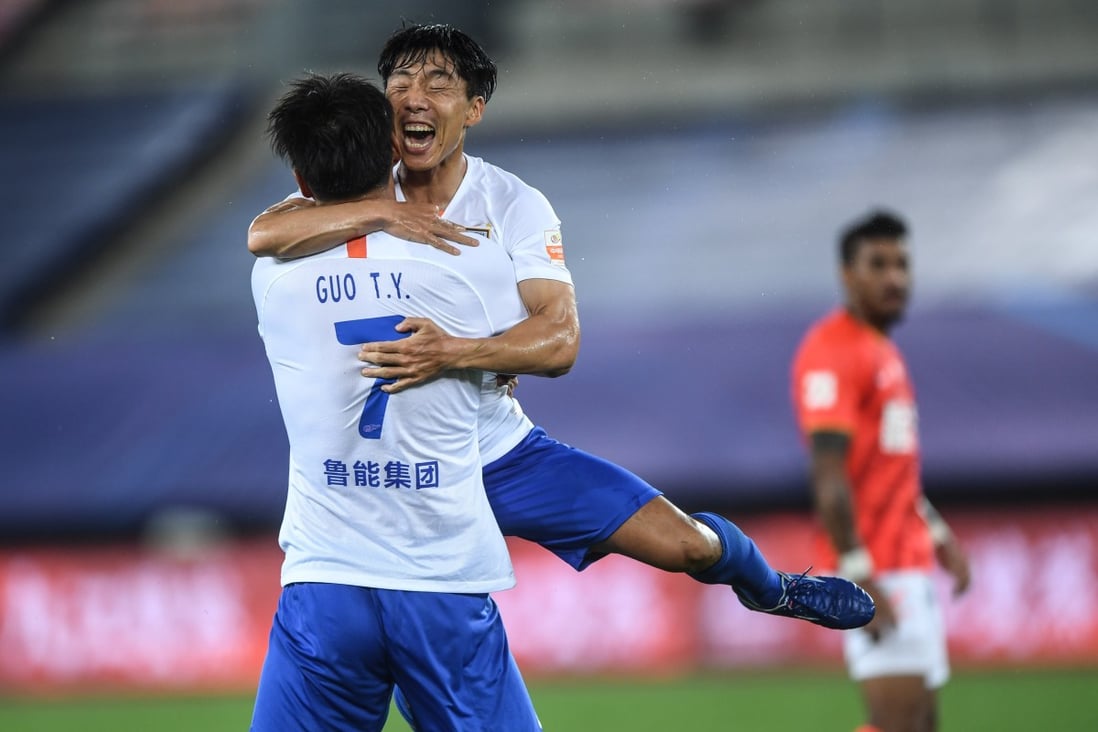 Shandong Luneng’s Guo Tianyu celebrates with Jin Jingdao after scoring against Guangzhou Evergrande in their Chinese Super League game. Photo: Xinhua