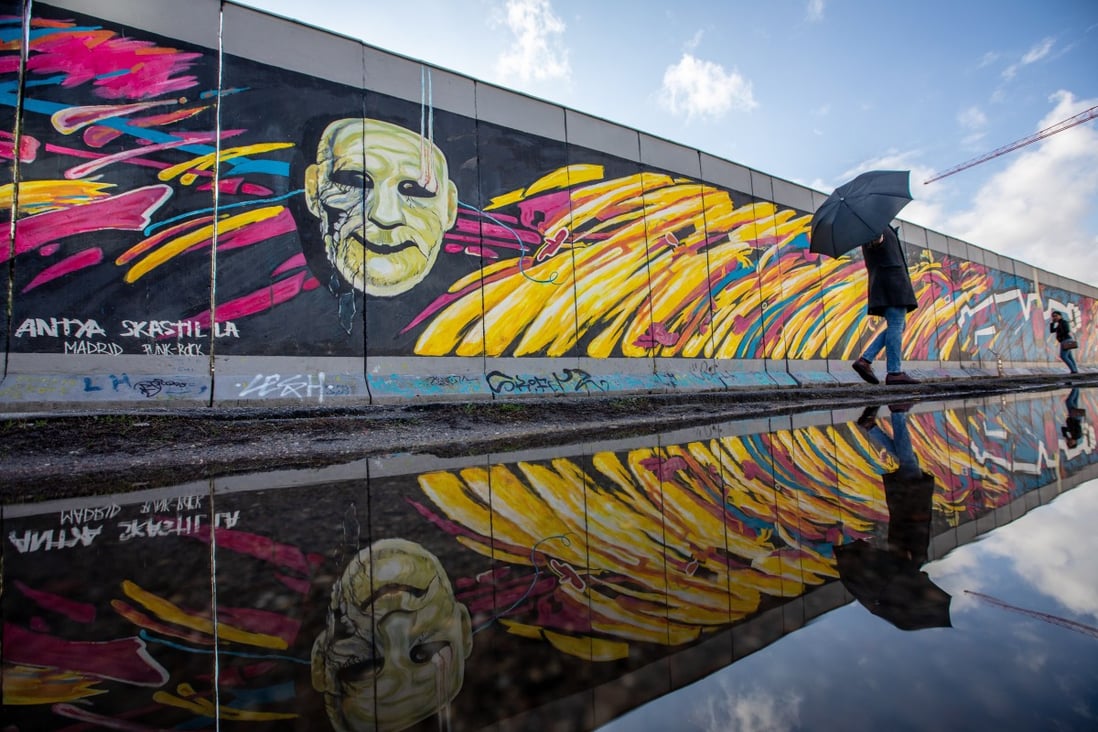 A visitor is reflected in a puddle along the East Side Gallery in Berlin. The lack of a geopolitical focal point akin to Berlin during the Cold War is one of several reasons that drawing parallels between US-China and US-Soviet-Union competition misses the mark. Photo: EPA