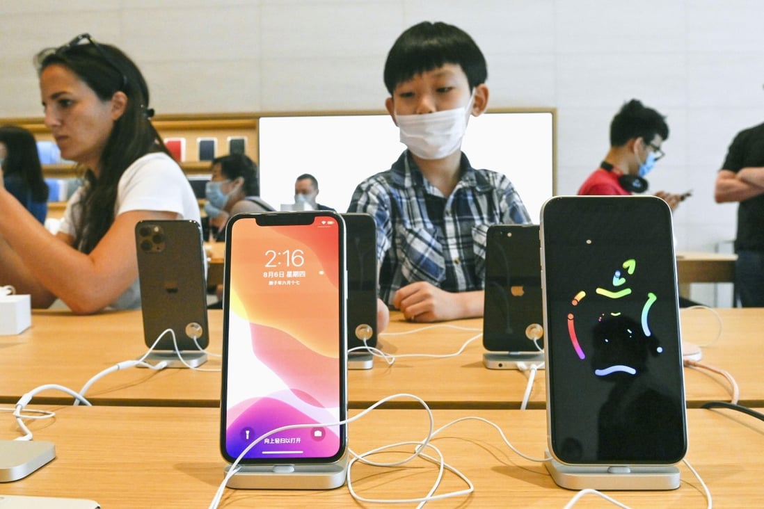 Shoppers check out the latest iPhone models at an Apple Store in Beijing on August 6. Photo: Kyodo