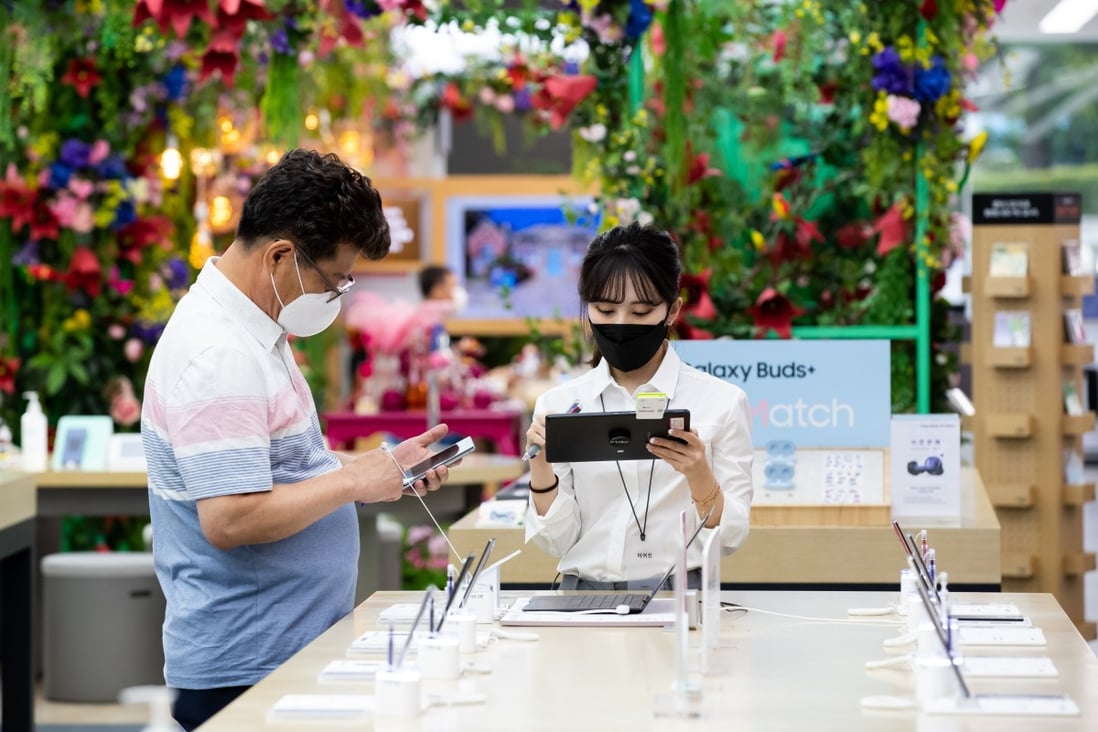 A visitor wearing a protective mask tries out a Samsung Electronics Galaxy Note 10 smartphone. Photo: Bloomberg